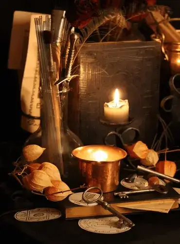 Velas encendidas, libro, inciensos, ajos y herramientas para la creación de rituales personalizados y manifestación de magia en tu casa.