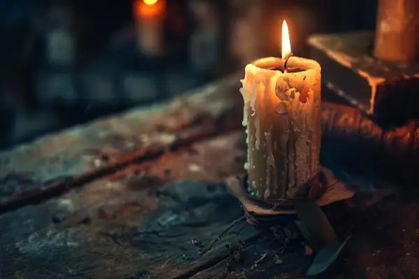 Vieja vela encendida sobre una mesa rústica, simbolizando la apertura de caminos y la iluminación espiritual.