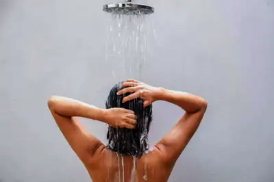 Baño de Descarga Espiritual 7 Mujer de espaldas bajo la ducha realizando un baño de descarga espiritual para purificación y energía positiva