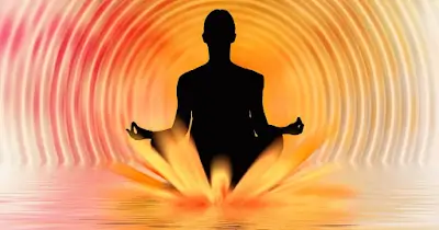 Silueta de persona meditando con halo de colores que representa: ¿Qué es el aura?