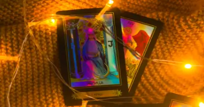 Cartas del tarot iluminadas con guirnaldas de luces en un entorno de hechicería digital