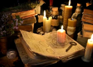 La Voz de la Bruja Paz 7 Revelaciones 8 Mesa de bruja con libros antiguos, velas encendidas, una llave mística y elementos rituales para decretos de poder.