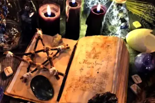 Libro de hechicería abierto con estrella de cinco puntas, velas encendidas y cristales para la Apertura de Caminos.