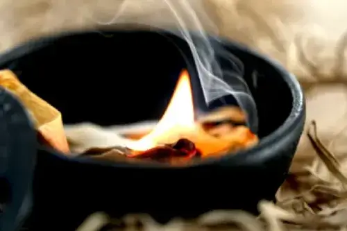 Cuenco con inciensos ardiendo durante el ritual Abre Caminos para el Hogar.