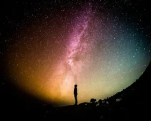 Silueta de un hombre bajo un cielo nocturno estrellado y la Vía Láctea, representando el acto de hablar con el universo y la manifestación espiritual.