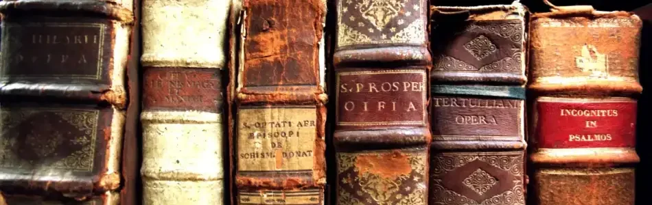 Varios libros muy antiguos en estante, evocando La Voz de la Bruja 7 Revelaciones y su sabiduría ancestral